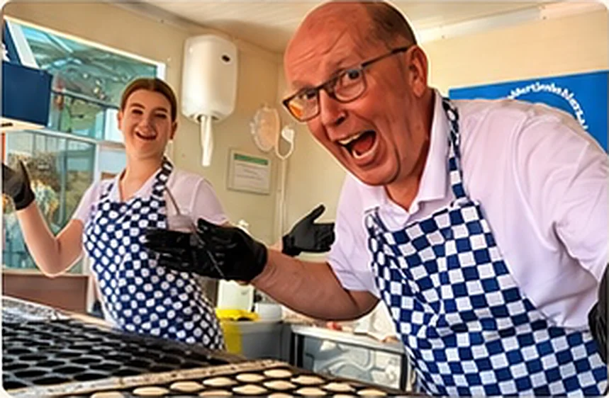 Enthousiaste bakker in een geblokt schort bij de poffertjeskraam
